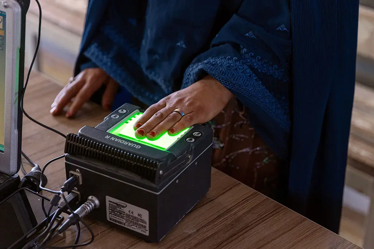 Las trabajadoras humanitarias, con el apoyo de ONU Mujeres, ayudan a las personas repatriadas a realizar un registro biométrico que les permite acceder a los servicios necesarios en Takhta Pul, cerca de la frontera con Pakistán