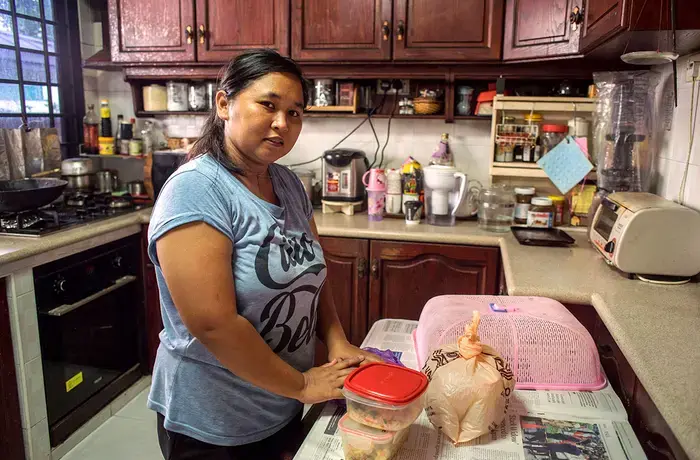 Nurachayatun an Indonesian domestic worker from Surabaya Java, prepares food inher employers kitchen after early morning grocery shopping.Photo: UN Women/Staton Winter