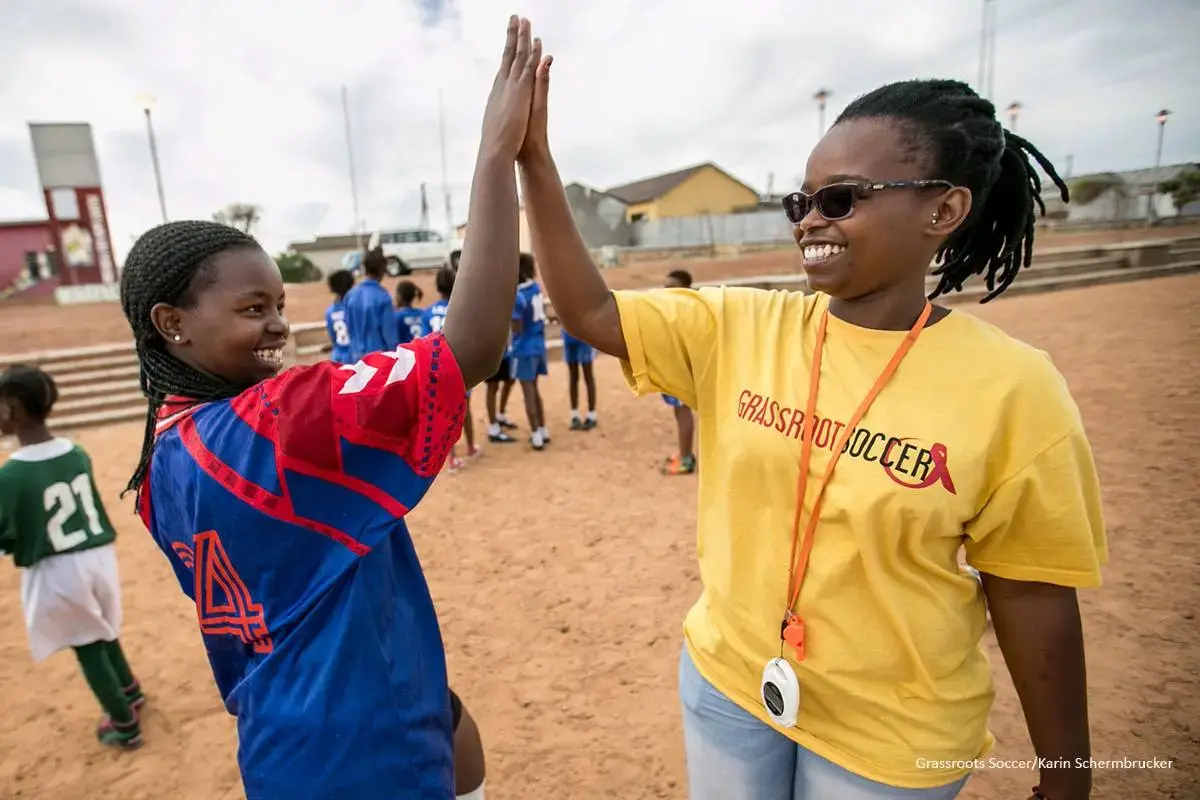 Yamkela (14 años) vive en Khayelitsha, donde el día a día es un reto contra la pobreza, el VIH y el SIDA y las limitadas infraestructuras sociales. Sin embargo, ella lo combate jugando con el equipo Grassroot Soccer SKILLZ Street, una organización que aprovecha el poder del fútbol para educar, inspirar y movilizar a los jóvenes. «Me ha dado mucha confianza, porque sé lo que me espera. Me siento orgullosa de mí misma por formar parte del lado positivo, del lado seguro.» Sudáfrica, 2016. Foto: Grassroots Socc